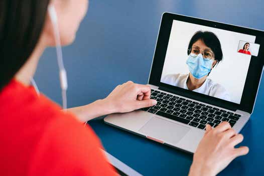 A patient on a laptop video call with a clinician.