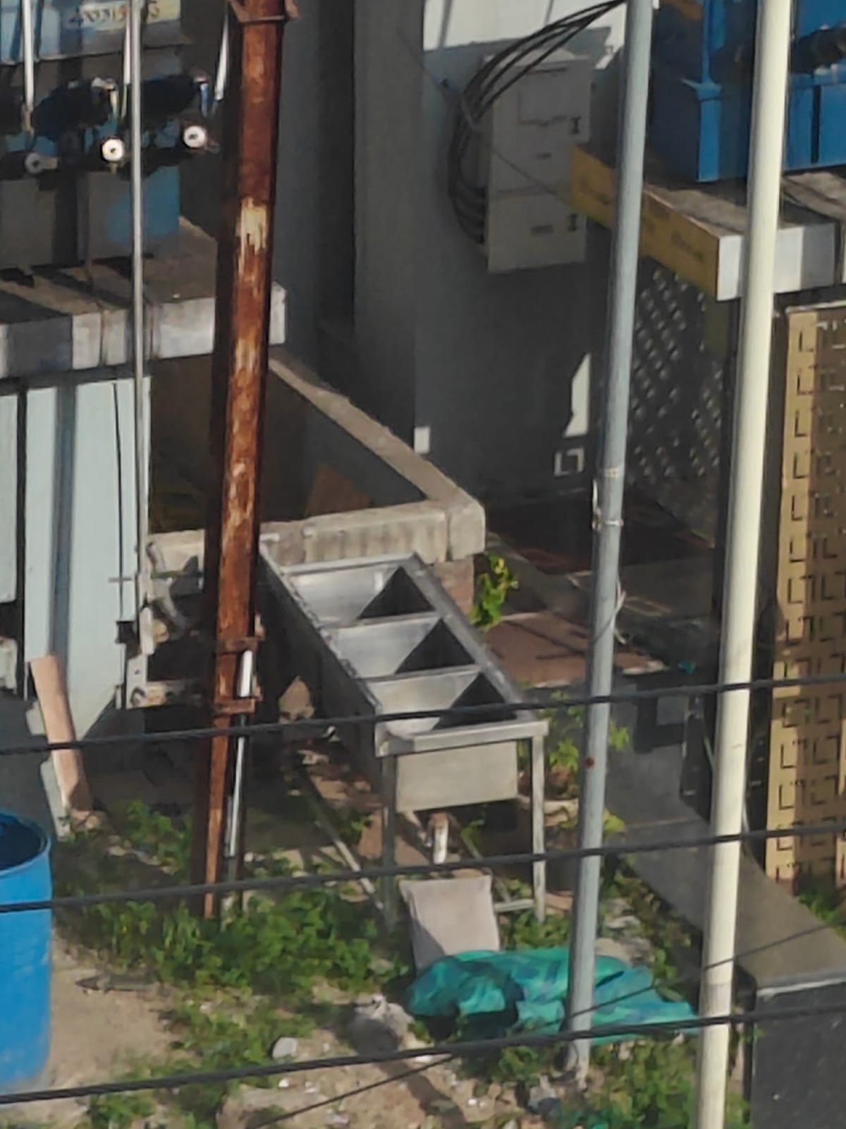 A metal trough behind a building, then the same trough drawn as a swimming pool with two stick figures in it.
